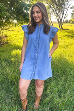 girl in blue short sleeve denim dress  and brown boots with green background