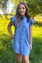 girl in blue short sleeve denim dress with green background