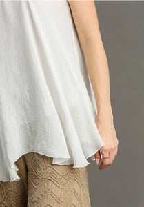 White top and beige pants worn by a person on a plain background