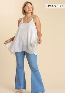 Woman wearing a white top and blue jeans on a beige background with 'Plus Size' text.