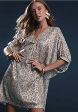 Woman wearing a patterned dress against a dark background leopard print