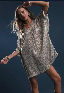 Woman wearing a patterned dress against a dark background leopard print