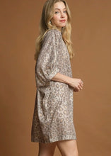 Woman wearing a patterned dress against a brown background leopard print