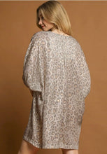 Woman wearing a patterned dress against a brown background leopard print