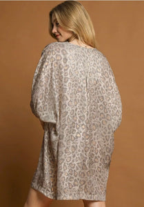 Woman wearing a patterned dress against a brown background leopard print