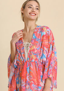 Woman wearing a colorful patterned dress on a beige background