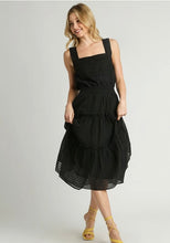 Woman wearing a black dress on a plain background