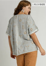 Woman wearing a gray plus size top with a subtle pattern on a plain background