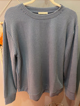 Folded gray sweater on a light-colored surface