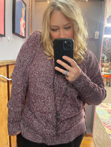 Woman with blonde hair wearing a purple textured sweater v neck long sleeves