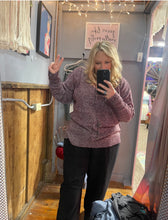 Woman with blonde hair wearing a purple textured sweater v neck long sleeves
