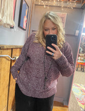 Woman with blonde hair wearing a purple textured sweater v neck long sleeves