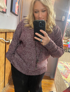 Woman with blonde hair wearing a purple textured sweater v neck long sleeves