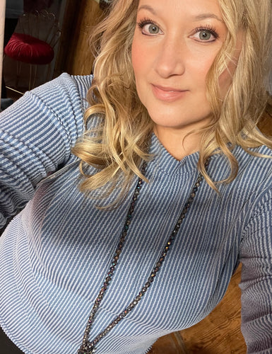 Woman wearing a blue and white striped sweater with a blurred background