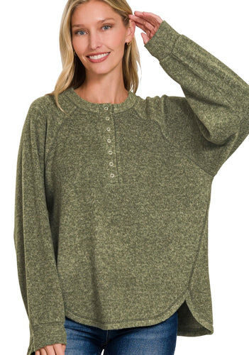 Woman wearing a green long-sleeve shirt with buttons on a white background