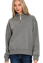 Woman wearing a gray zip-up sweatshirt on a white background
