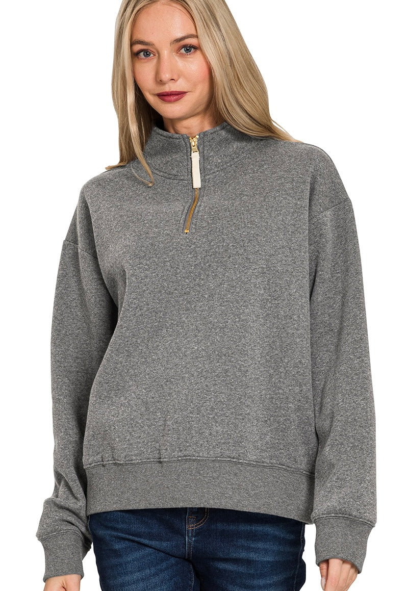 Woman wearing a gray zip-up sweatshirt on a white background
