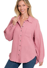 Woman wearing a pink button-up shirt with a white background