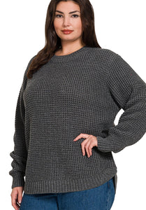 Woman wearing a gray textured sweater on a white background