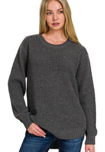 Woman wearing a gray textured sweater on a white background