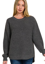 Woman wearing a gray knitted sweater on a white background