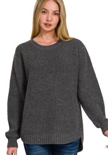 Woman wearing a gray knitted sweater on a white background