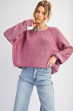 Woman wearing a pink sweater and light blue jeans on a white background