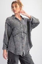 Woman wearing a faded black  shirt with rolled-up sleeves on a white background