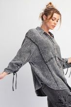 Woman wearing a faded black  shirt with rolled-up sleeves on a white background