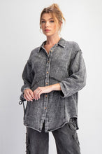 Woman wearing a faded black shirt with rolled-up sleeves on a white background