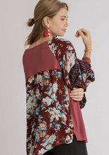 Woman wearing a floral kimono-style top on a plain background