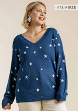 Woman wearing a blue sweater with star patterns on a beige background