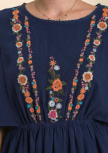 Navy blue dress with colorful floral embroidery on a plain background