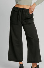 Black wide-leg pants worn by a person on a gray background