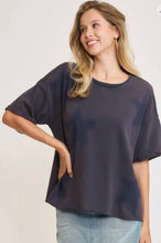 Woman wearing a dark navy oversized sweatshirt short sleeves with stars on a plain background