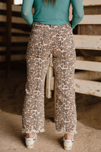 Person wearing leopard print pants in a rustic setting