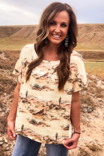 Woman wearing a desert-themed shirt in a natural landscape