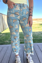 Person wearing blue jeans with horse and nature pattern outdoors