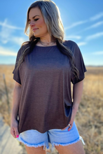 Woman wearing a brown ombre t-shirt and denim shorts in a desert setting