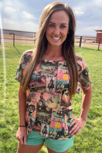 Woman wearing a colorful patterned shirt standing in a grassy field.