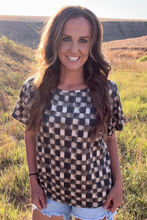 Woman wearing a checkered shirt in an outdoor setting