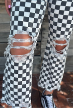 Black and white checkered pants with ripped knees on a blurred background